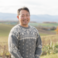 自家门前就是颇具北海道风情的一望无垠的美瑛小麦田。 （川村勲 摄影）