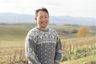 自家门前就是颇具北海道风情的一望无垠的美瑛小麦田。 （川村勲 摄影）